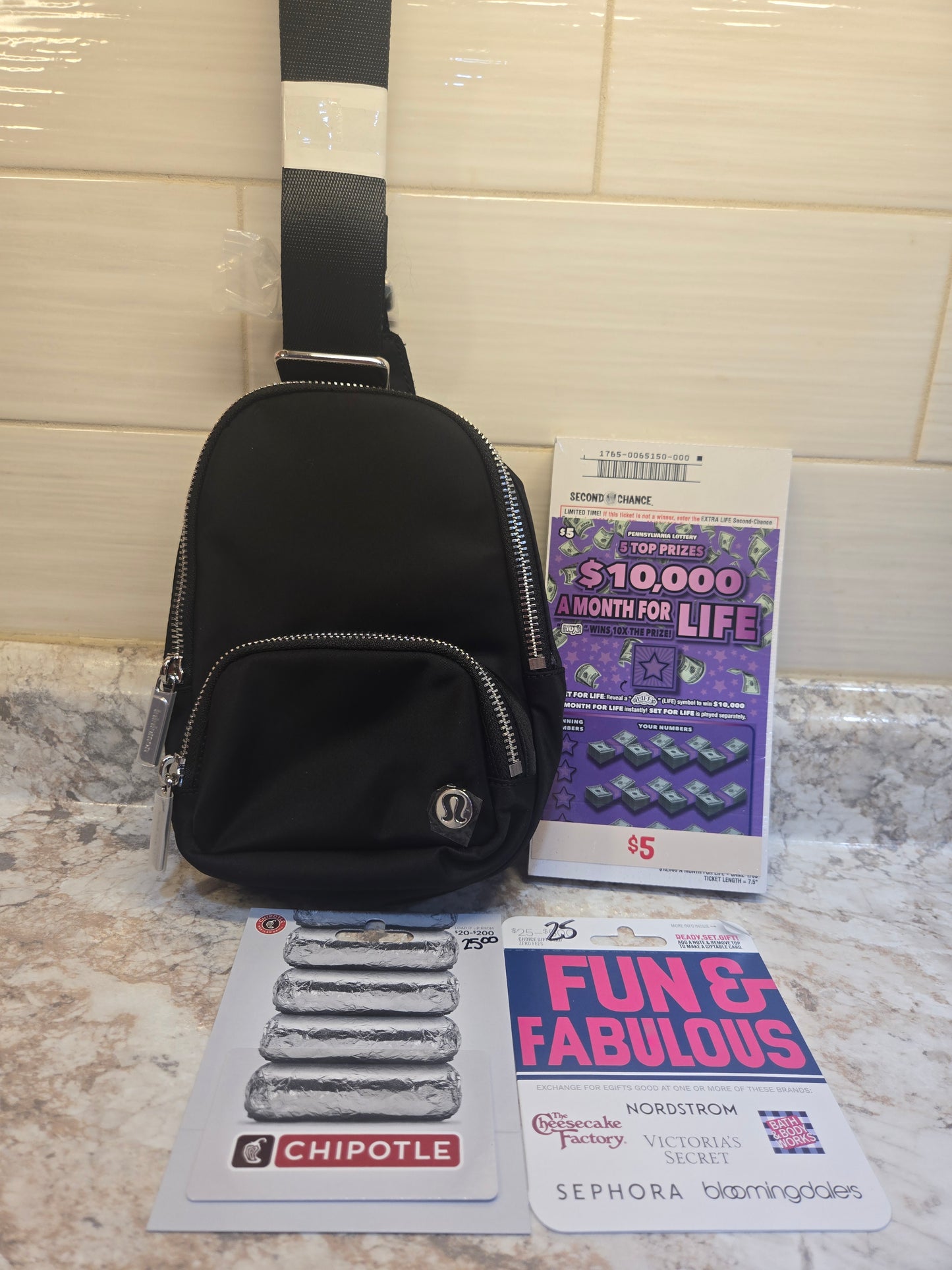 $5 brick of 10k a Month for Life, $50 gift cards, Lululemon sling bag serial # 87718